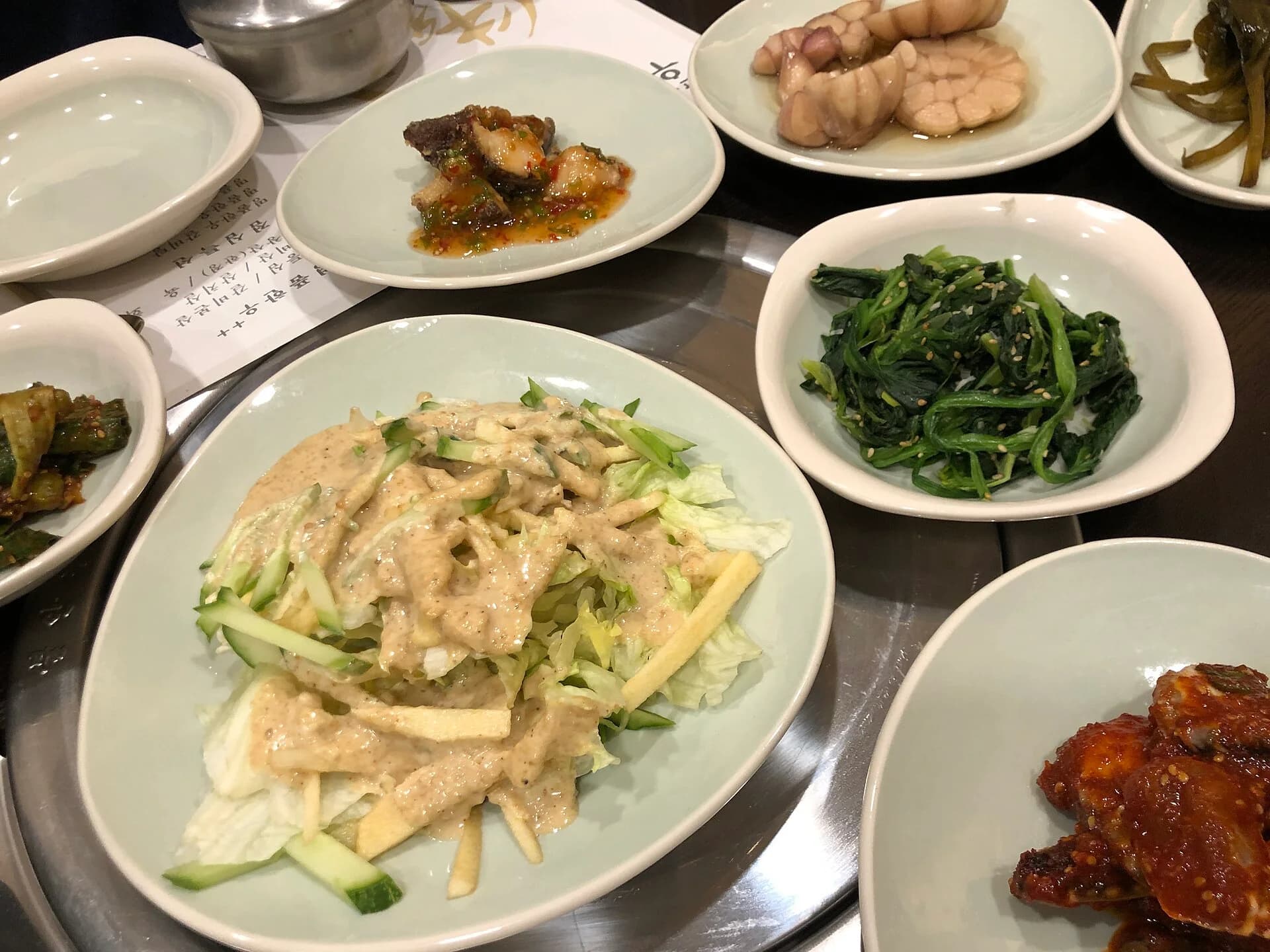 Several shared Korean side dishes arranged across a restaurant table