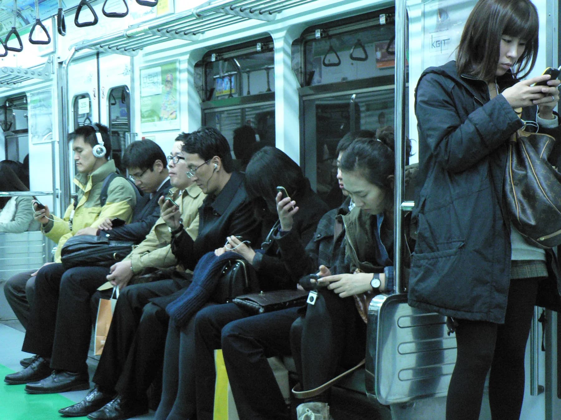 Passengers using phones on the Seoul Metro