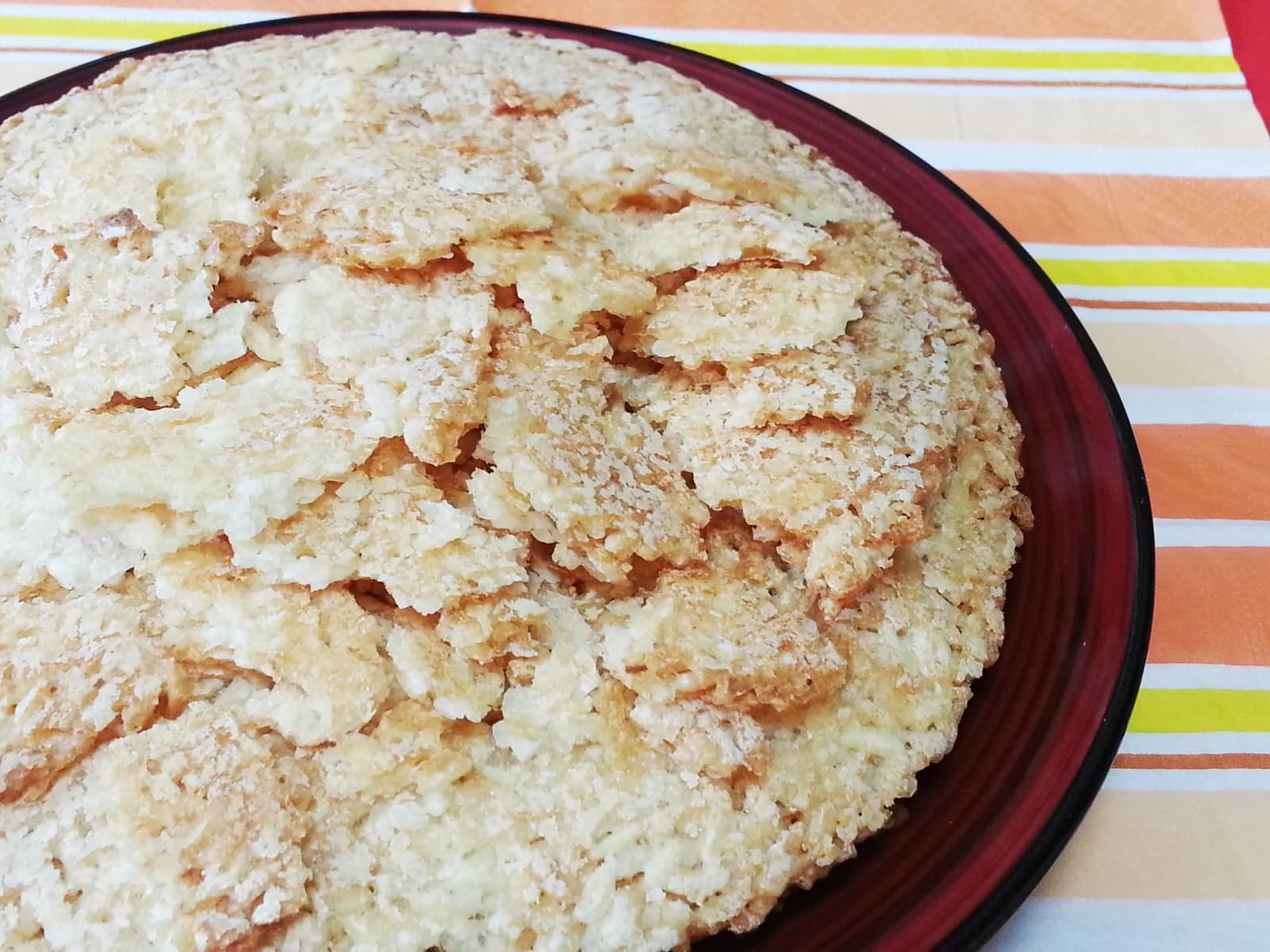 Golden sheets of scorched rice with visible grains piled on a plate