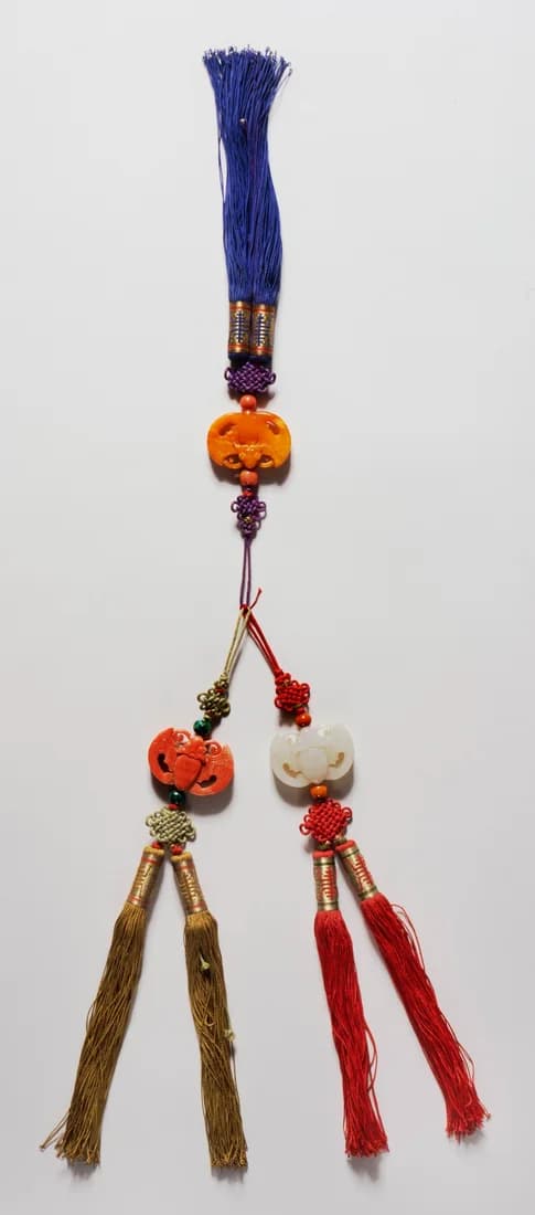Joseon-period norigae with blue, red, and gold tassels and carved amber, coral, and jade ornaments.