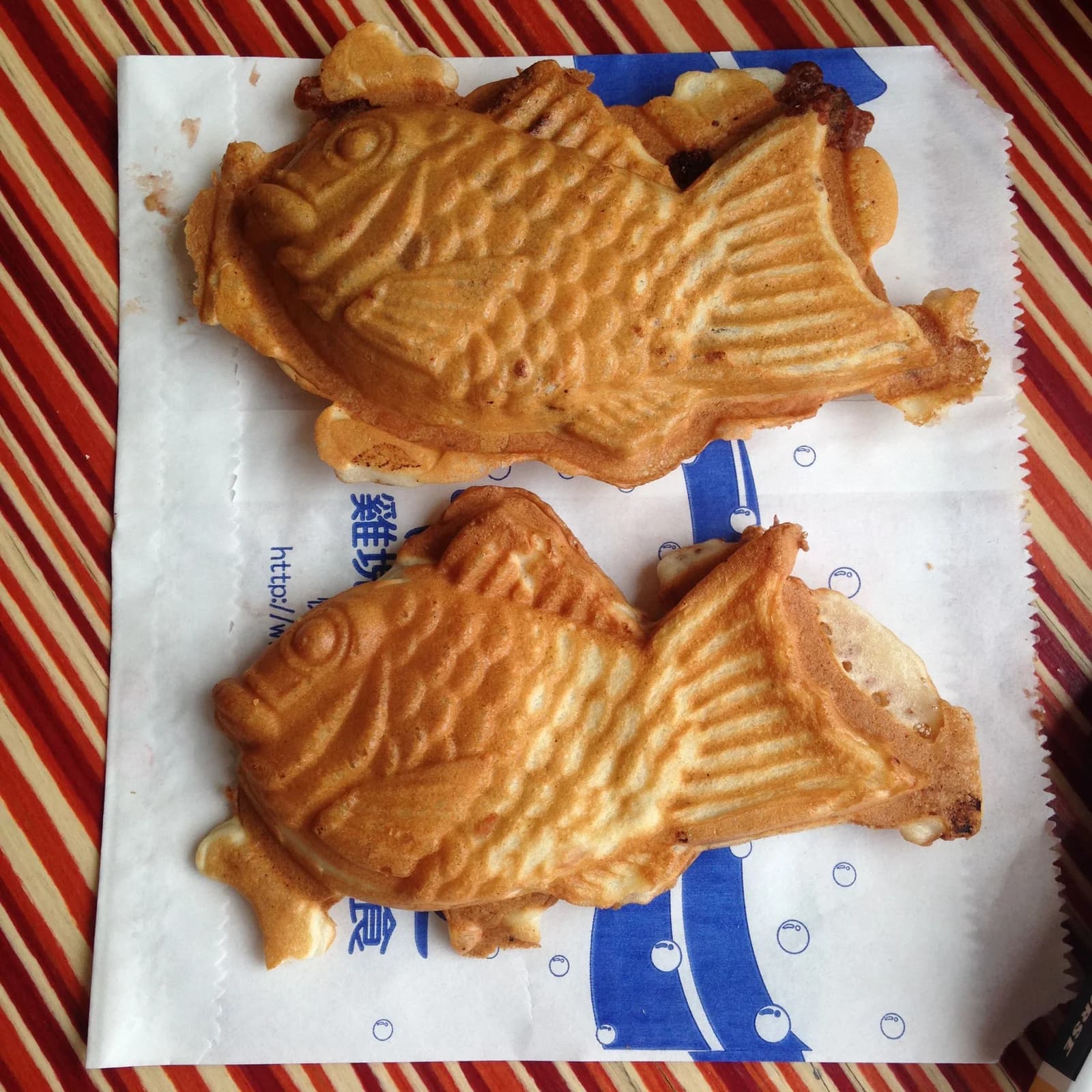 Two golden fish-shaped bungeoppang with molded scales and tails