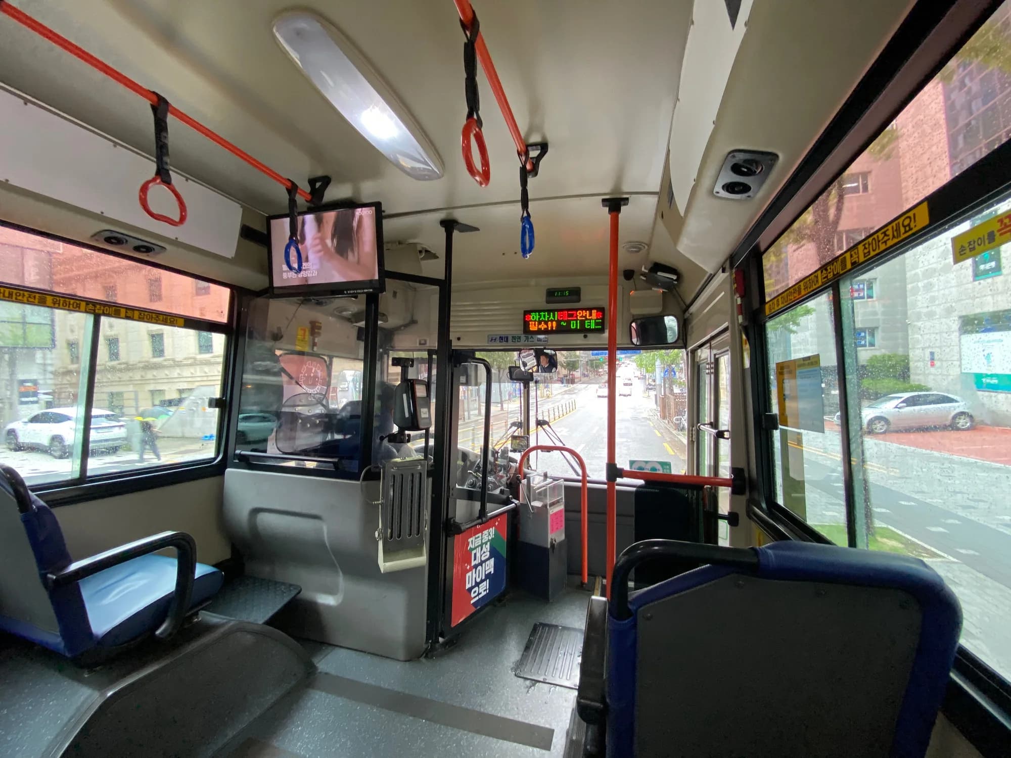Interior of a Seoul city bus viewed toward the driver and front door